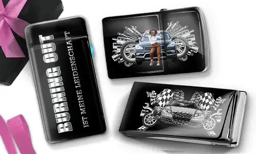 Drei schwarze Geldbörsen mit Auto-Designs. Eine trägt die Aufschrift „Burning Out ist meine Leidenschaft“, eine andere zeigt ein Auto mit Kolben und einer Person, und die dritte zeigt ein Auto mit karierten Flaggen und Kolben. In der Ecke liegt eine violette Schleife.