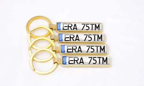 Gouden nummerplaat sleutelhangers tonen gepersonaliseerde nummers samen gerangschikt