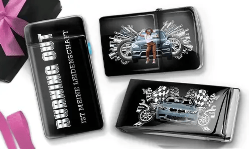 Drei schwarze Geldbörsen mit Auto-Designs. Eine trägt die Aufschrift „Burning Out ist meine Leidenschaft“, eine andere zeigt ein Auto mit Kolben und einer Person, und die dritte zeigt ein Auto mit karierten Flaggen und Kolben. In der Ecke liegt eine violette Schleife.