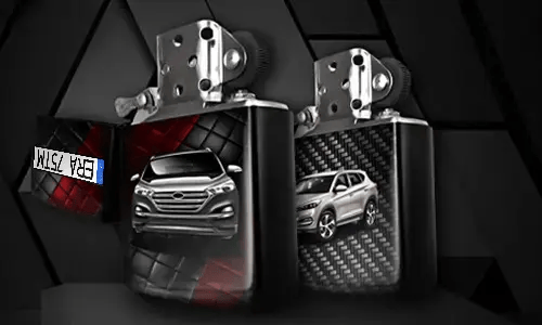 Two metallic lighters with silver SUV designs: one front view on tread background, one side view with carbon texture, small rectangular object in corner